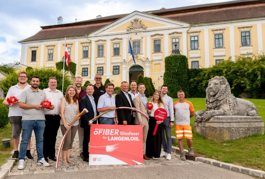 Bild zeigt eine Gruppe von Personen, verschiedener Geschlechter vor dem Weingut Schloss Gobelsburg,mit diversen oefiber Schildern und roten Helmen, mit dem öGIG Logo